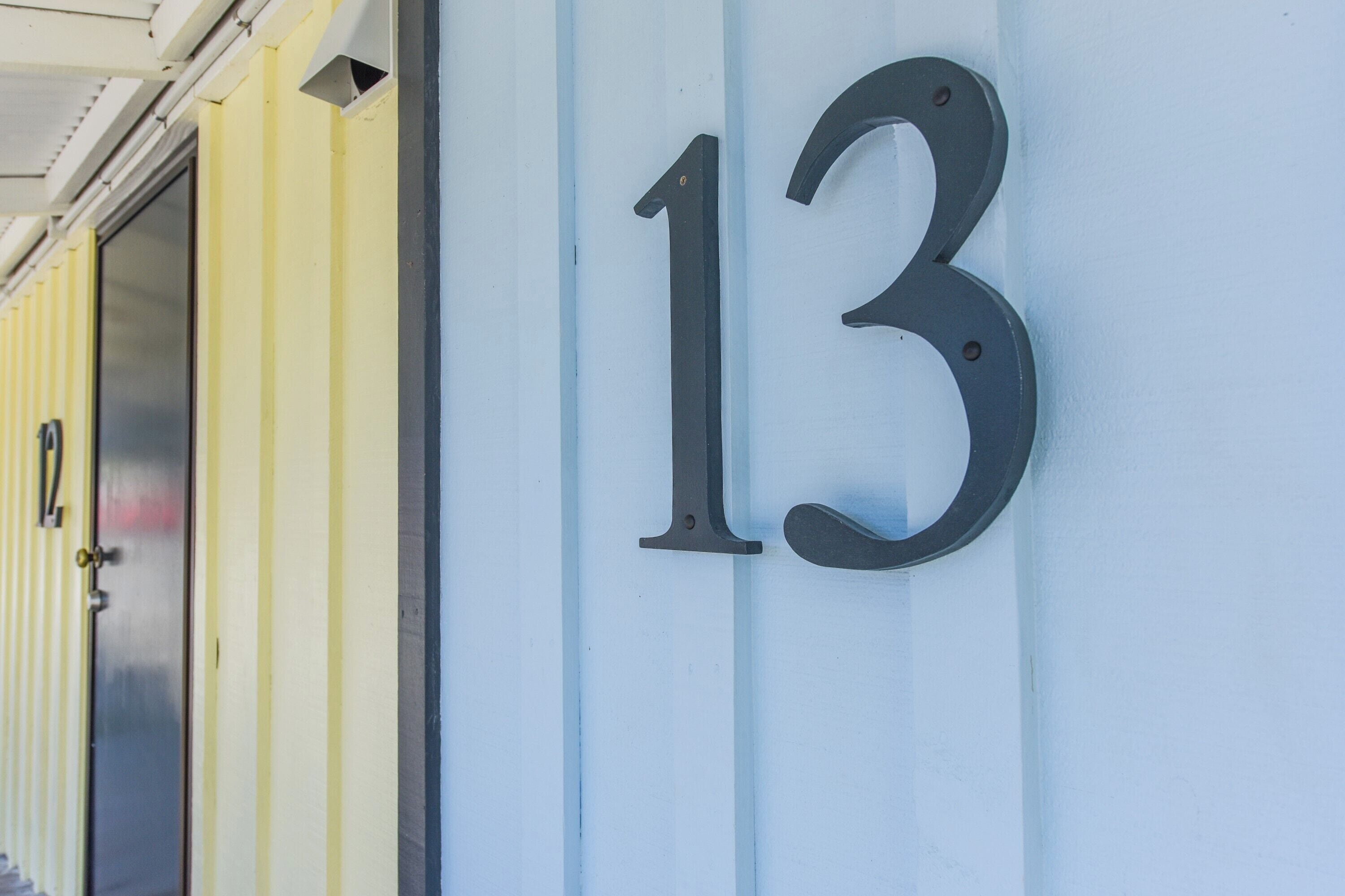 Un numéro de bâtiment, le « 13 », est affiché sur un mur de couleur claire.