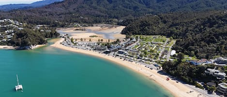 Eine Luftaufnahme einer Küstenregion mit Strand, einer Marina und einem Wohngebiet mit Häusern und Straßen.