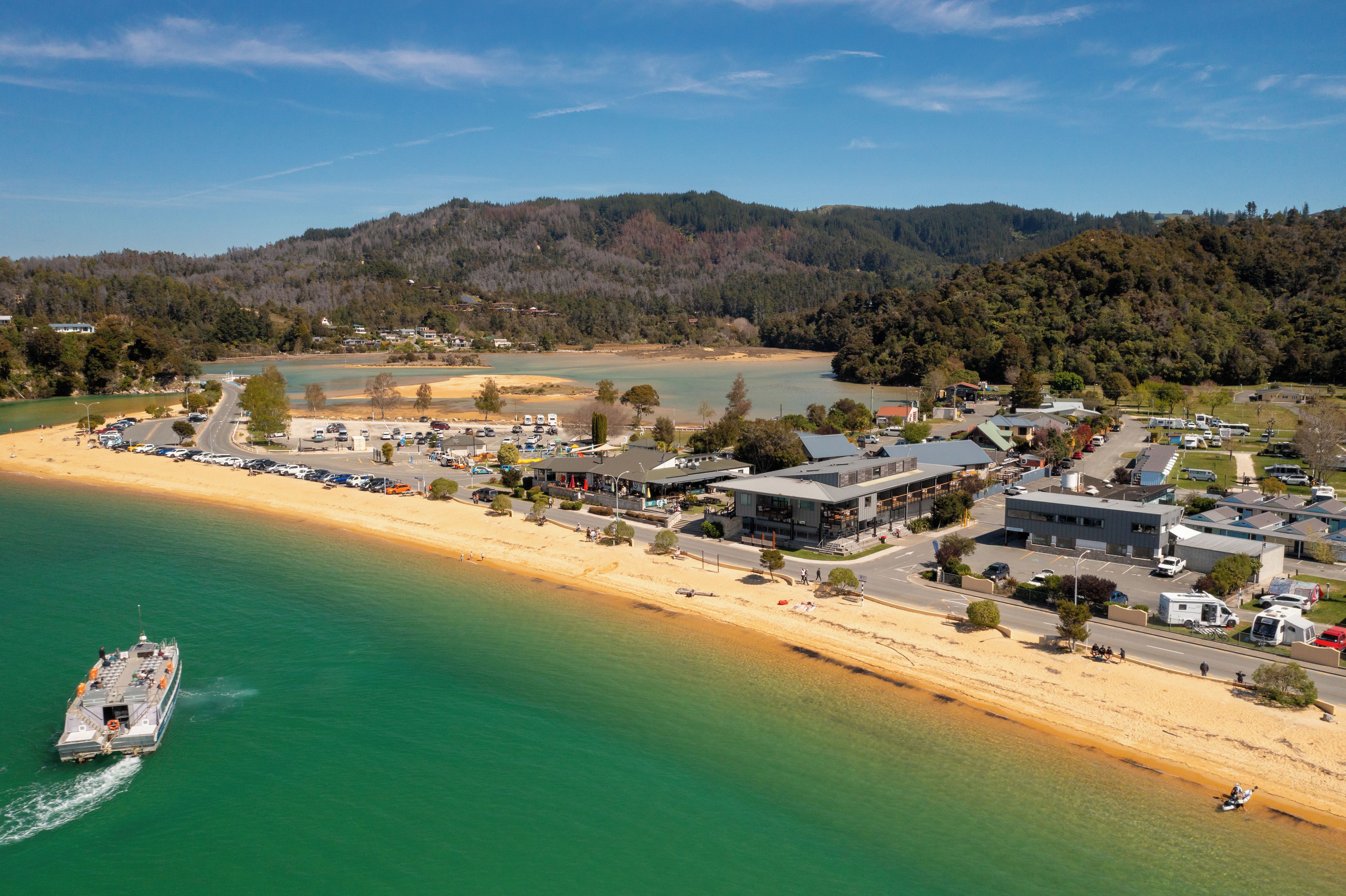 A coastal town with a beach, a marina, and a mix of residential and commercial buildings.