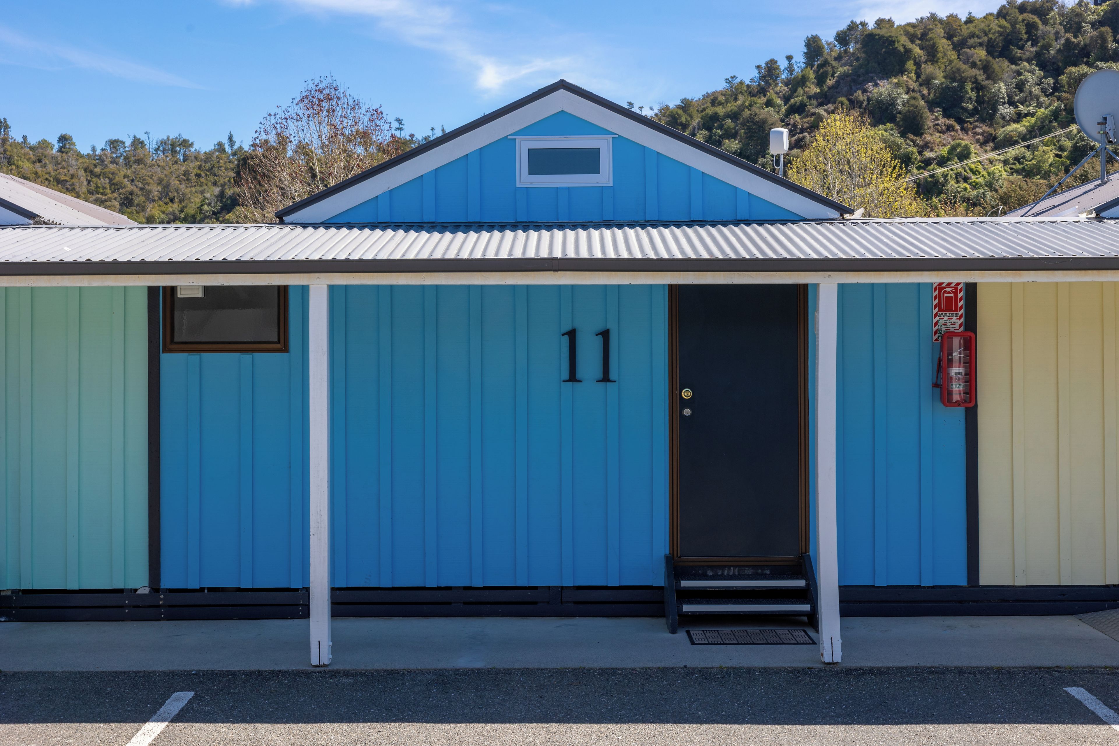 A small, single-story building with a blue facade and the number 11.