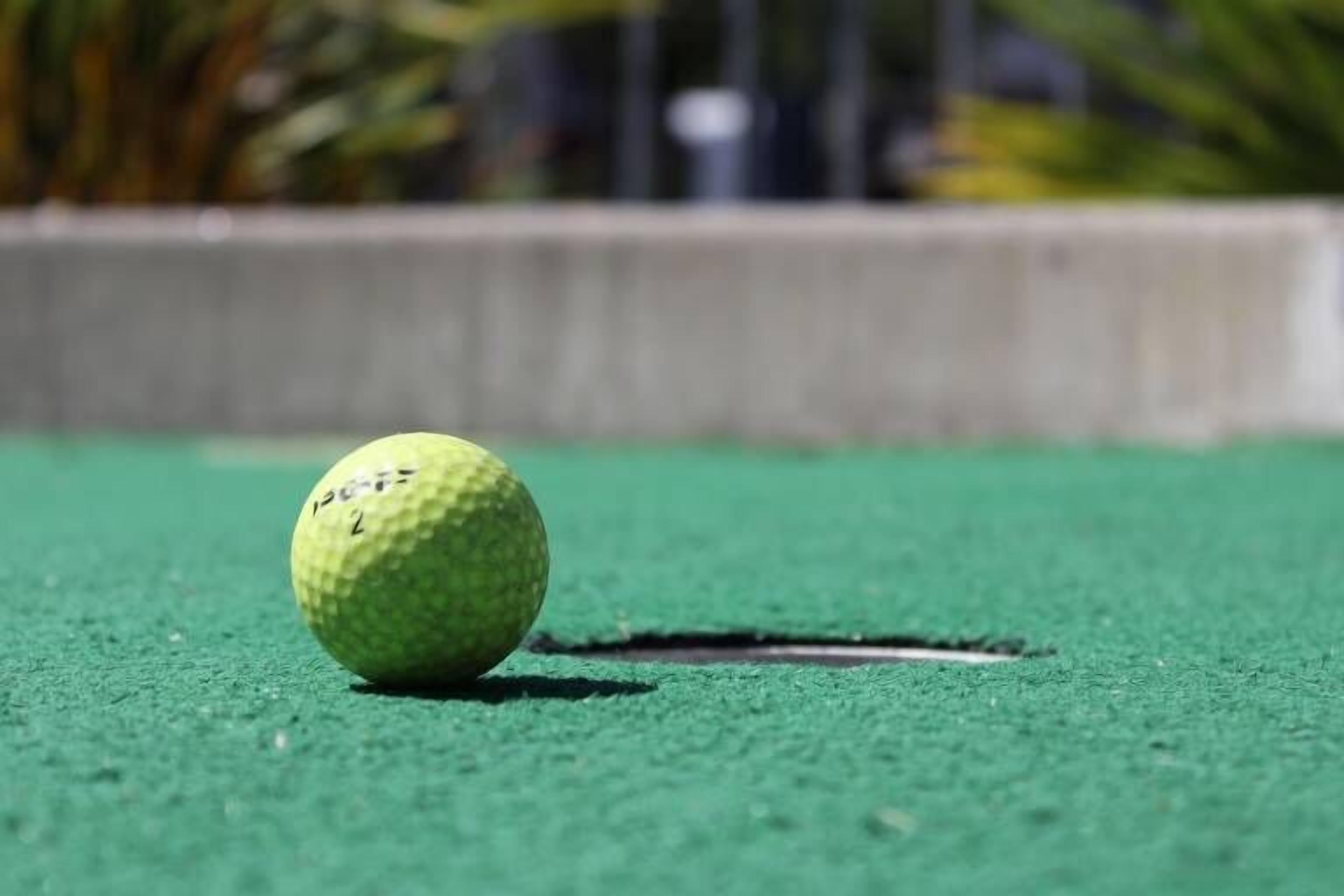 A golf ball on a green surface.