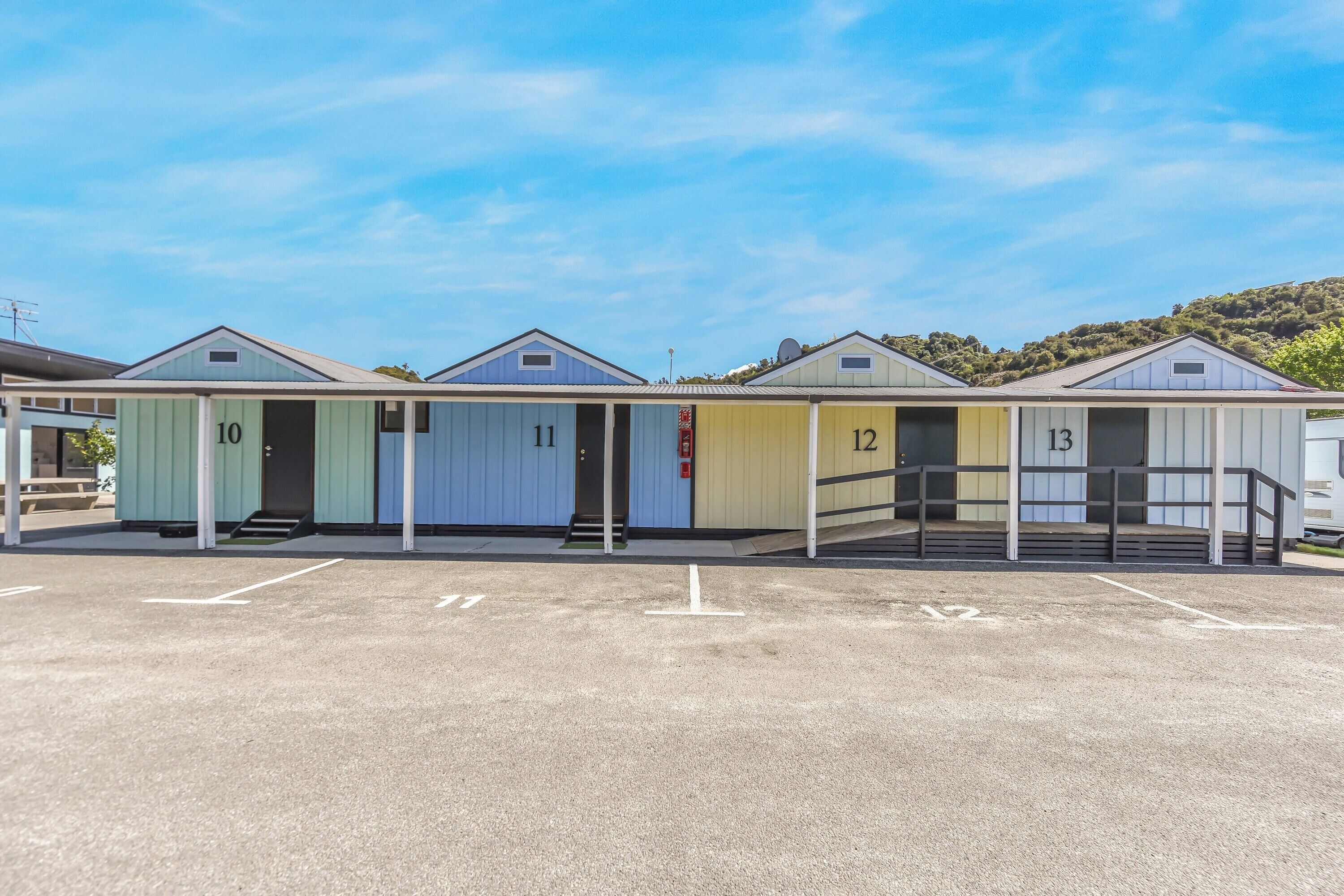 Filas de casas móviles numeradas con un cielo despejado y un paisaje montañoso al fondo.