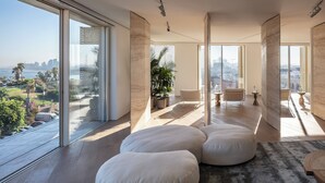 Un espai saló ampli amb grans finestres, vista a la ciutat i un disseny interior modern.