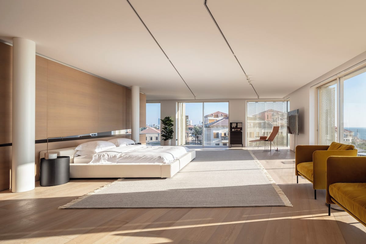 A spacious bedroom with a large bed, a sofa, and a TV.