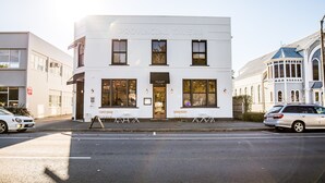 A white building with "Provincial Tavern" signage, a door, and windows. - Provincial Apartment 2 (Nelson)
