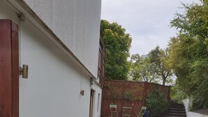 A narrow pathway leading to a wooden deck with steps, surrounded by gravel and plants. - Apartm. in a family house with 2 bedr. and a living room with 2 beds (RVK)