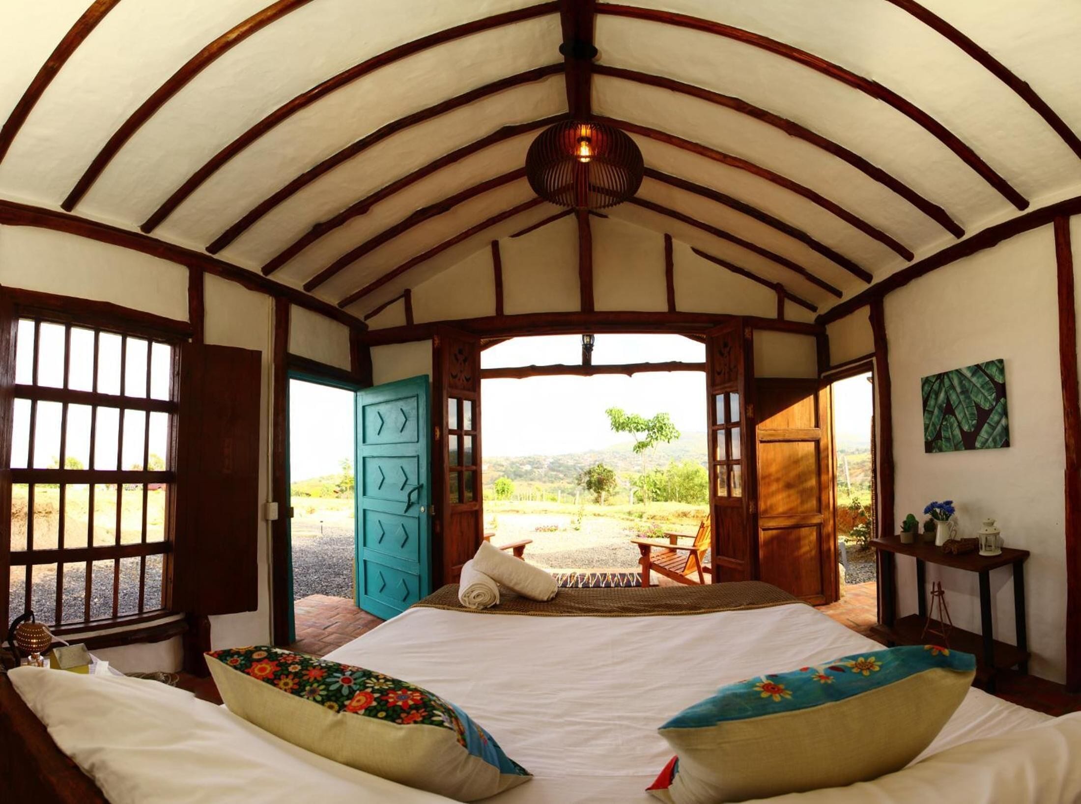 A room with a bed, a window, and a view of the outdoors.