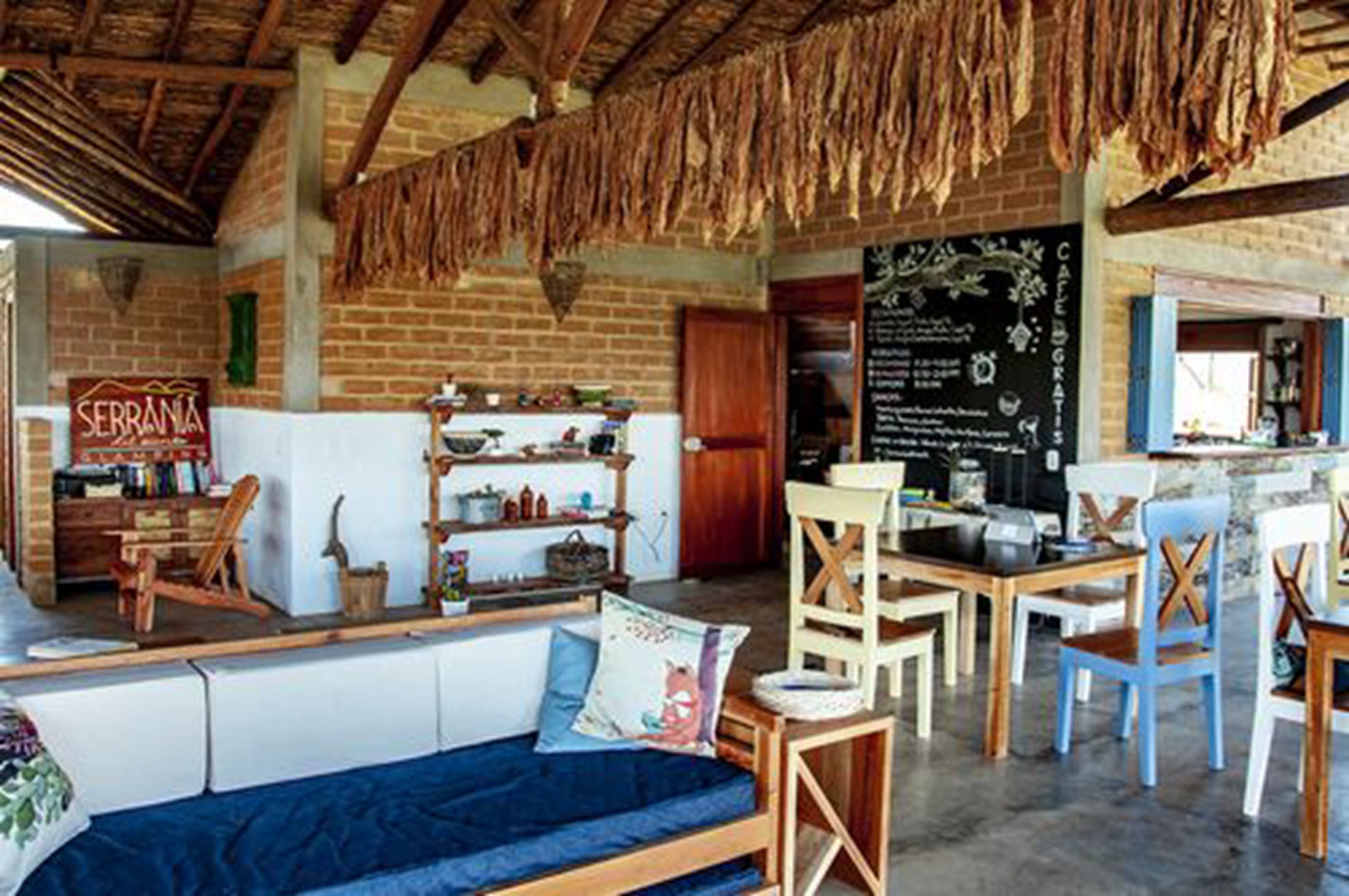 Un interior rústico con pared de ladrillo, muebles de madera y un menú en pizarra.