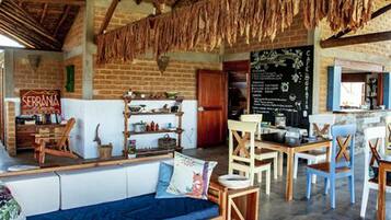 Un interior rústico con pared de ladrillo, muebles de madera y un menú en pizarra.