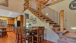 A spacious kitchen with wooden cabinets and a dining area with a wooden table and chairs. - Large Side Yard! 2 minutes to Table Rock Lake! (Hollister)