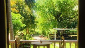 A patio with a tiled floor, a round table, and two wooden chairs. - KOANA Bungalows (Ko Pha-ngan)