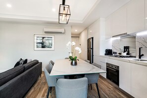 Departamento Deluxe, 2 habitaciones | Área de sala de estar | Televisión de pantalla plana de 42 pulgadas con canales vía satélite 
