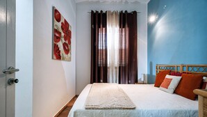 A bedroom with a bed, curtains, a painting, and a nightstand. - House near the sea, with shared pool, Marsala, Sicily - Marsala 2 (Marsala)