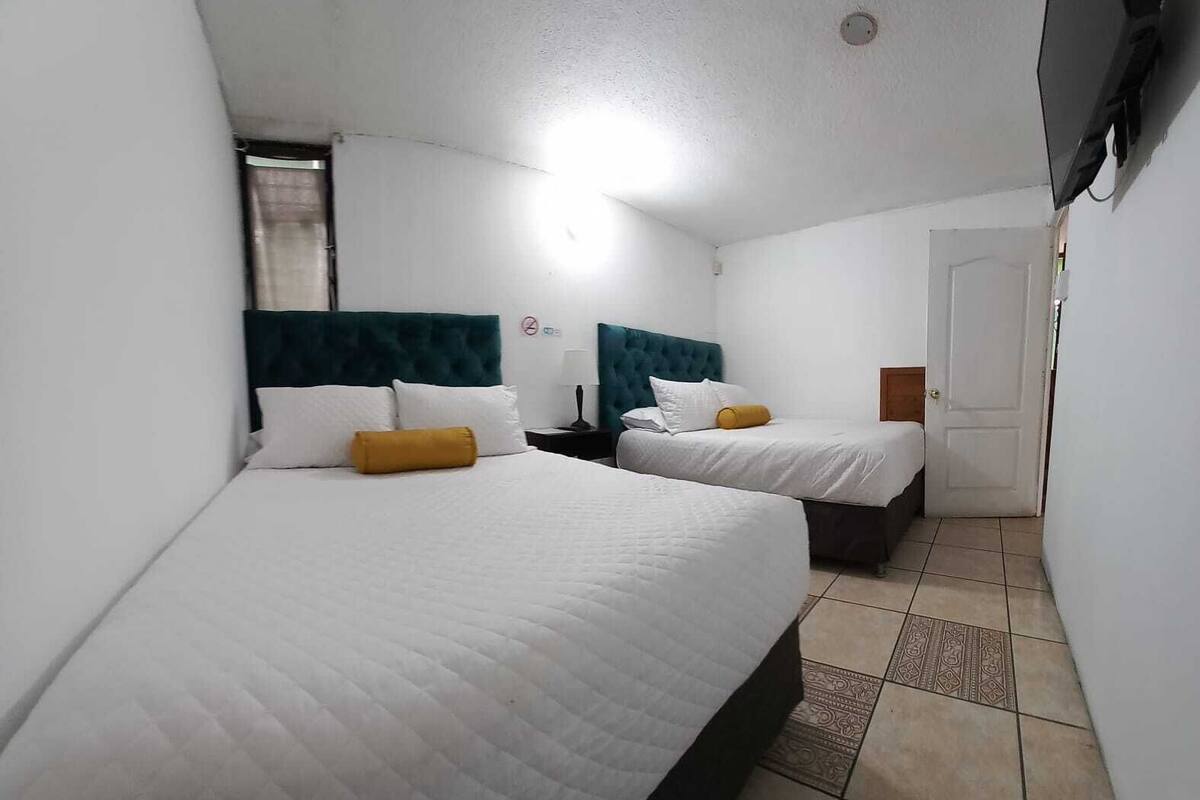 Une chambre d’hôtel avec deux lits, chacun doté d’une tête de lit et d’oreillers.