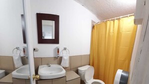 Een badkamer met twee wastafels, een toilet en een douchegordijn.