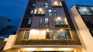 Un immeuble moderne à plusieurs étages, doté de balcons, de grandes fenêtres et d’un toit plat.