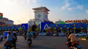 A busy street with a prominent clock tower labeled "CHO BEN THANH" and a building with "MUNG DANG QUAR" signage. - Moc Lan 1 Hotel (Ho Chi Minh City)