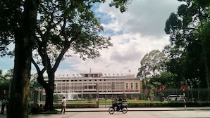 A building with a symmetrical facade, large windows, and a central flagpole. - Moc Lan 1 Hotel (Ho Chi Minh City)