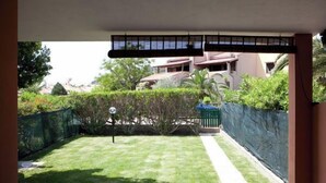 A view of a backyard with a lawn, a pathway, and a fence. - A beautiful villaetta overlooking the sea (COSTA REI)