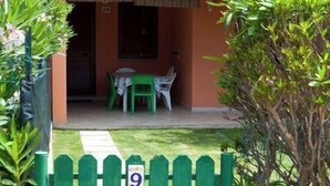 A house with a red-tiled roof, a green gate with the number 9, and a small patio with a table and chairs. - A beautiful villaetta overlooking the sea (COSTA REI)