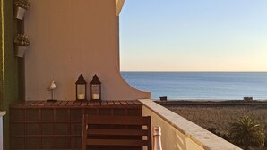 A dining table set for two with a view of the sea, a bottle of wine, and a small plant on the balcony. - Torralta Alvor Beach 601 (Alvor)