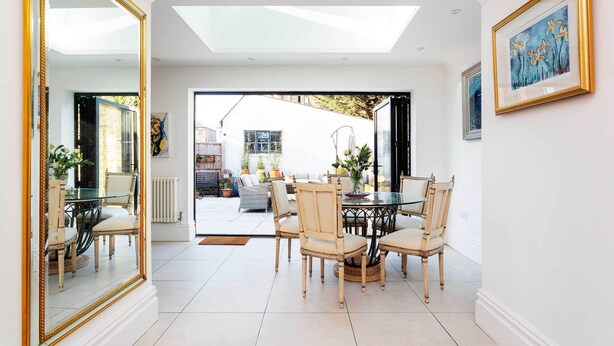 A dining area with a round table and chairs, a large mirror, and a view of the outside. - Richmond on Canvas, by Veeve (London)