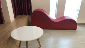 A room with a white round table with wooden legs, a red upholstered bench, and a wooden floor. - Moc Lan 3 Hotel (Ho Chi Minh City)