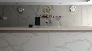 A reception desk with a marble wall, two clocks, a 'Vietnam' sign, a 'New York' sign, a 'Hello' sign, and a 'Success' sign. - Moc Lan 3 Hotel (Ho Chi Minh City)