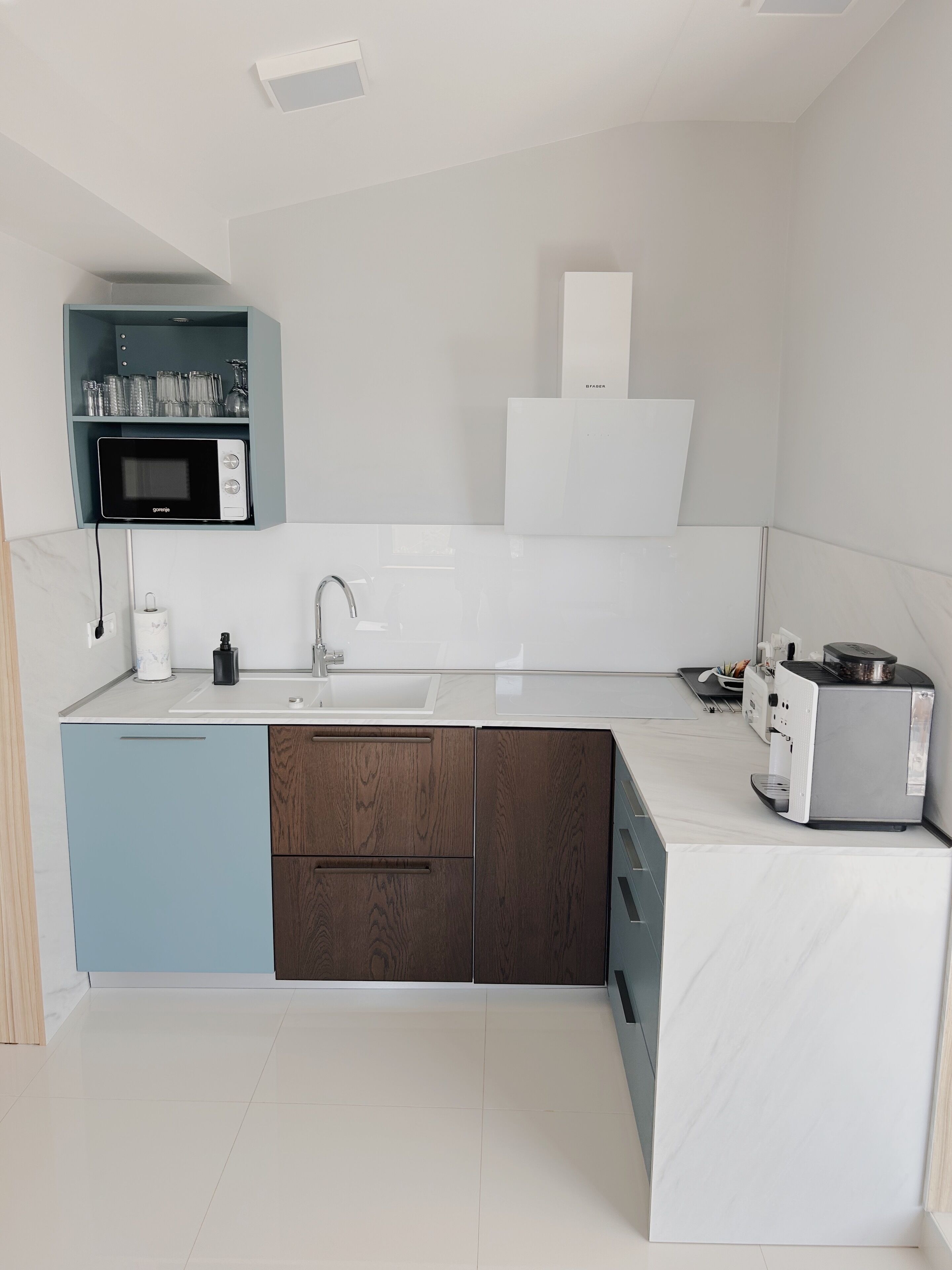 Eine moderne Küche mit Einbau-Mikrowelle, Spüle und Kaffeemaschine.