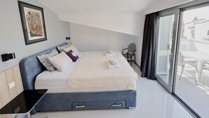 A modern hotel room with a large bed, a desk, and a chair. - October in Luxury Sea-View Stay near Sandy Beach (Zambratija)