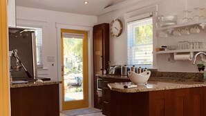 A modern kitchen with a central island, wooden cabinets, and a built-in oven. - NEW!!  The “WATERSIDE” COTTAGE~With dockage (Bokeelia)