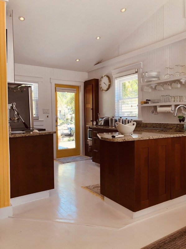 A modern kitchen with a central island, wooden cabinets, and a built-in oven.