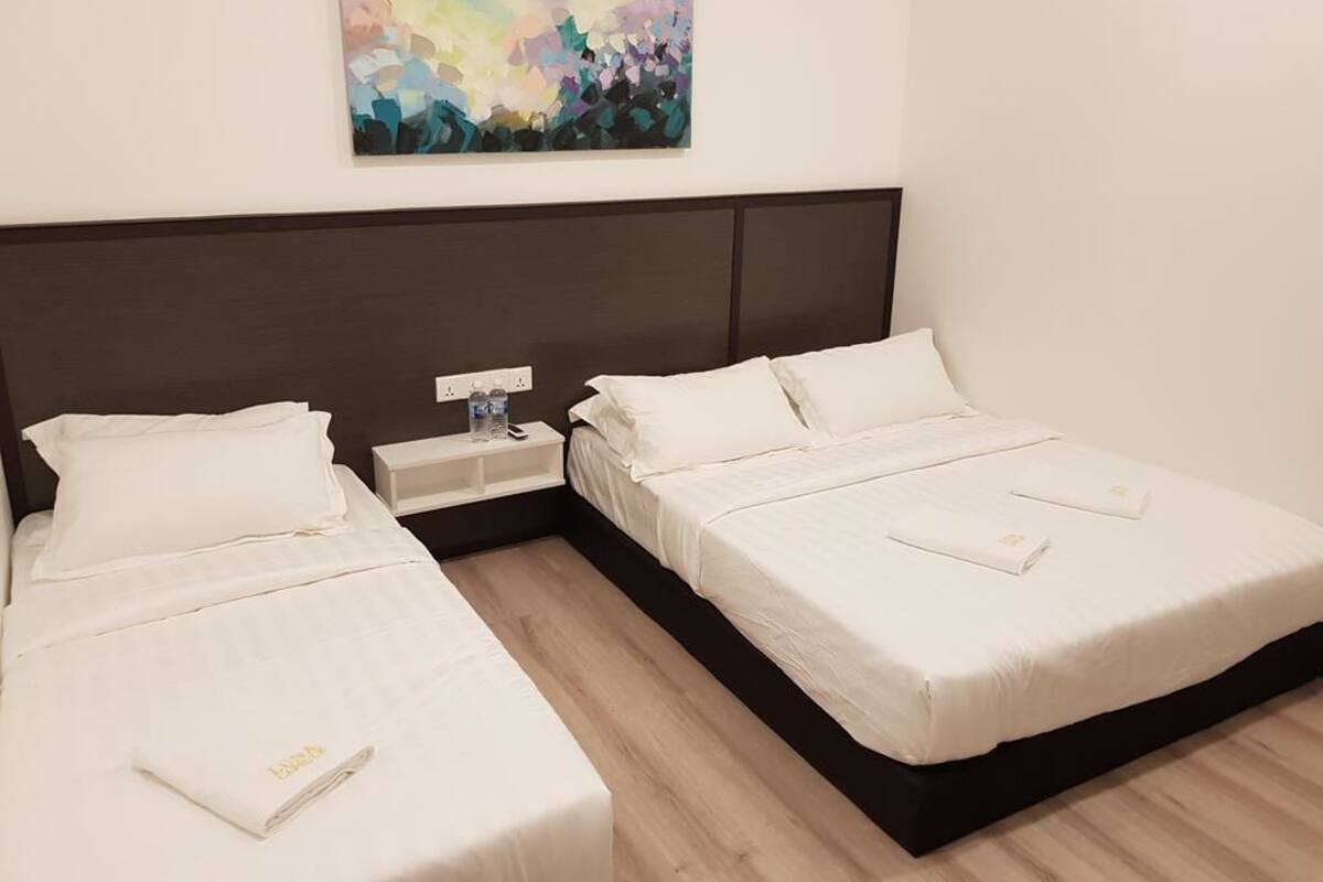 Une chambre d’hôtel avec deux lits, une table de chevet et un tableau au mur.