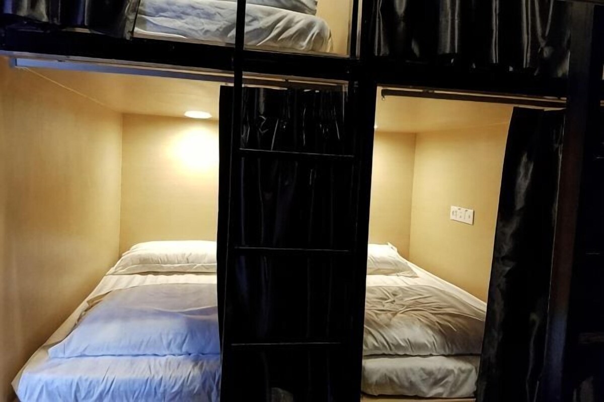 A bunk bed room with a single bed and a bunk above.