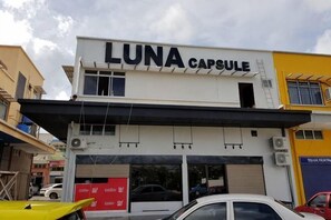 A building with a sign reading 'LUNA CAPSULE' and a garage door. - Luna Capsule (Semporna)