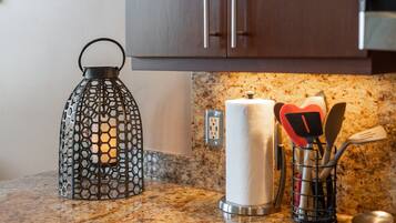 A kitchen counter with a metal lantern, a roll of paper towels, and a utensil holder.