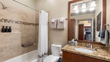 A bathroom with a bathtub, toilet, and sink.