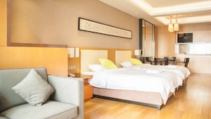 A modern hotel room with a large bed, a sofa, a dining area, and a kitchen. - Guangzhou Yiyuan Apartment (Guangzhou)