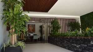 A modern interior with a dining area, a large potted plant, and a wall with vertical wooden slats. - MOMA Luxury condo Playa del Carmen (Playa del Carmen)