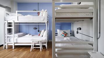 A room with two bunk beds, a small table, and a chair.