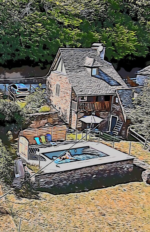 Ein Haus mit Schwimmbad, überdachter Terrasse und Bootsanleger.