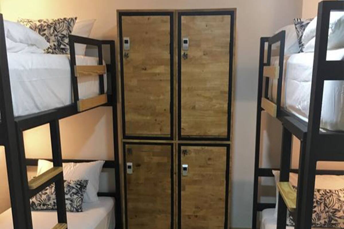 A room with bunk beds and a wooden wardrobe.