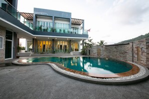 A modern house with a swimming pool, a balcony, and a brick wall. - The Ananas Serviced Apartments (Karon)