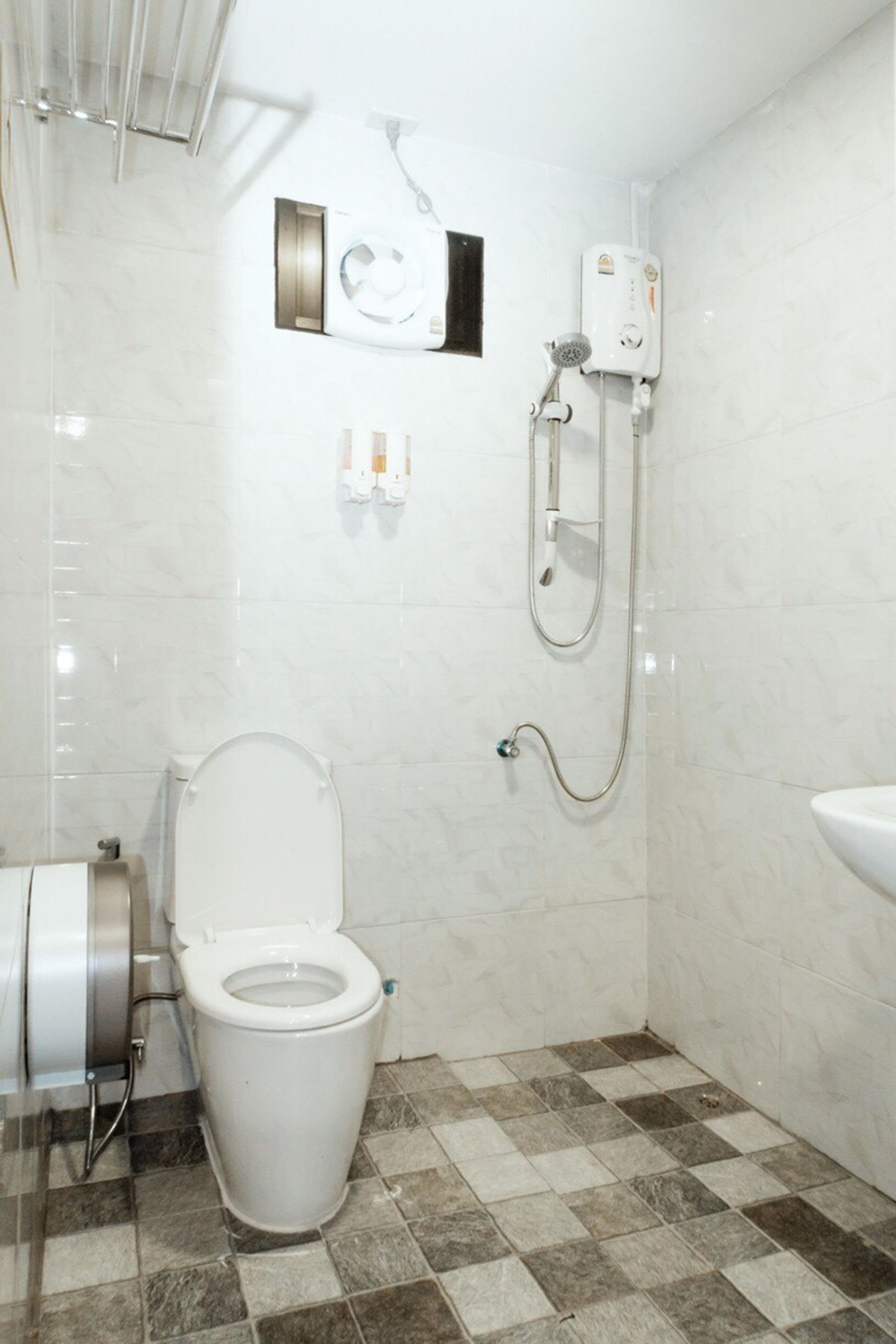 Een badkamer met toilet, douche en wastafel.