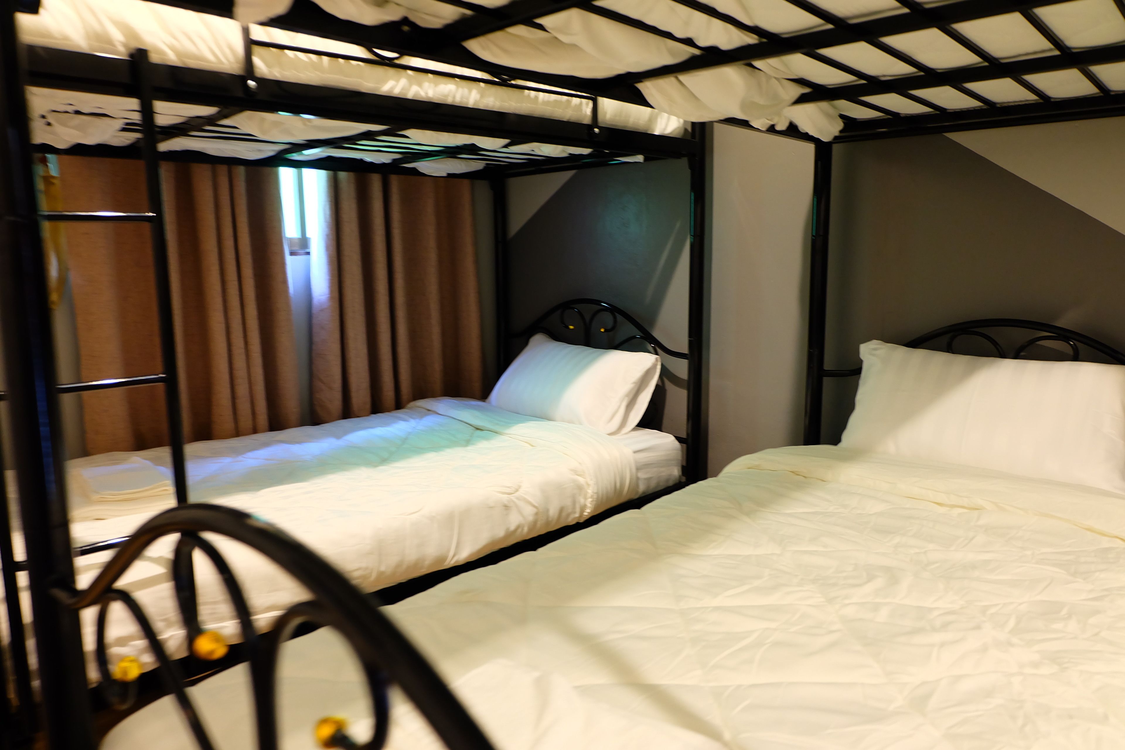 A bunk bed room with two beds, each with white bedding and a metal frame.