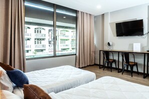 A hotel room with two beds, a desk, a chair, and a TV. - Full Moon' House - Hostel (Nakhon Si Thammarat)