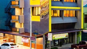 Ein mehrstöckiges Gebäude mit einem gut sichtbaren Schild 'Hilton House', das Balkone und ein Flachdach zeigt.