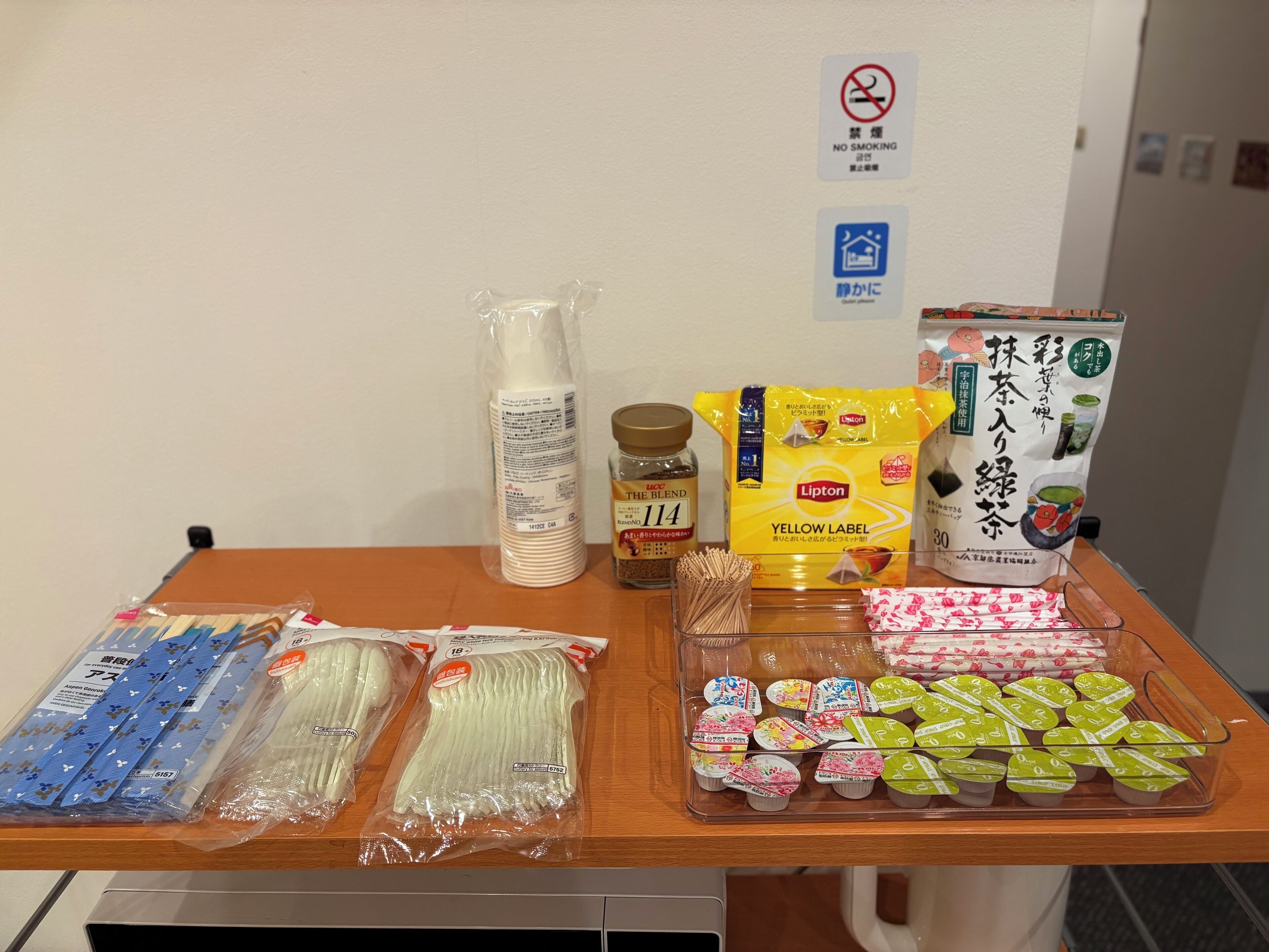 A table with various packaged food items, including instant noodles, Lipton tea, and packaged beverages.