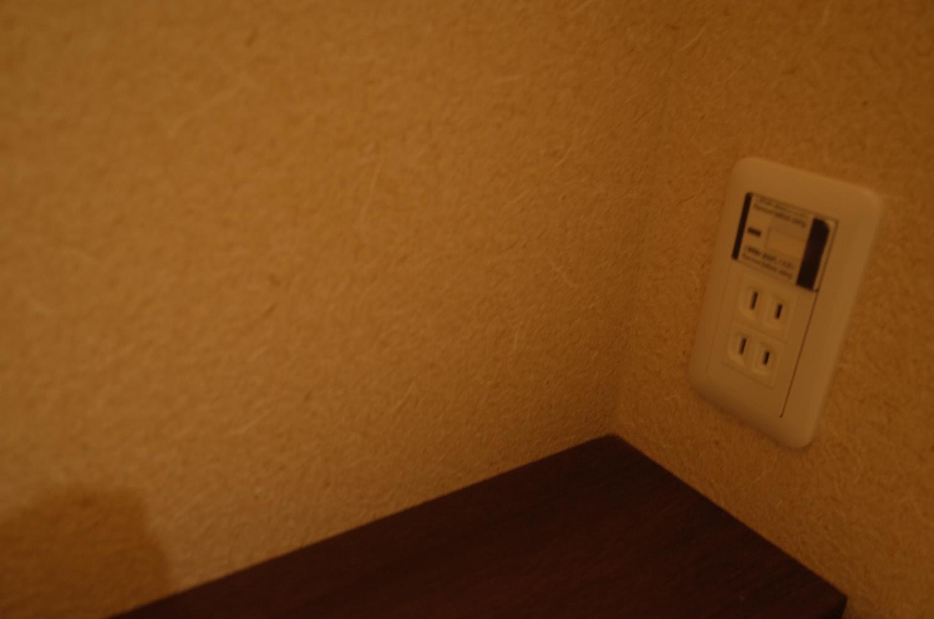 A white electrical outlet on a textured wall.