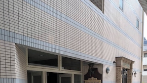 Un edificio con facciata piastrellata, ingresso in vetro e insegna con la scritta 'LAMP BAR'.